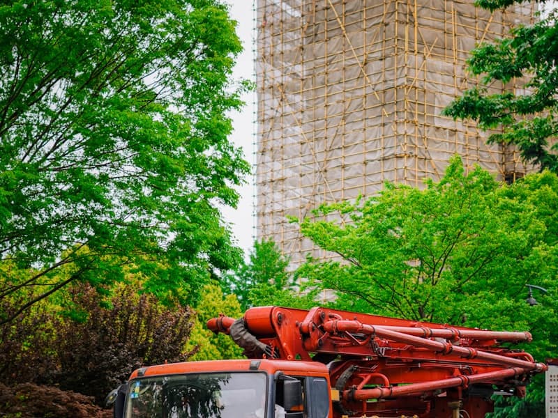 Concrete pump truck with boom extended on a city site